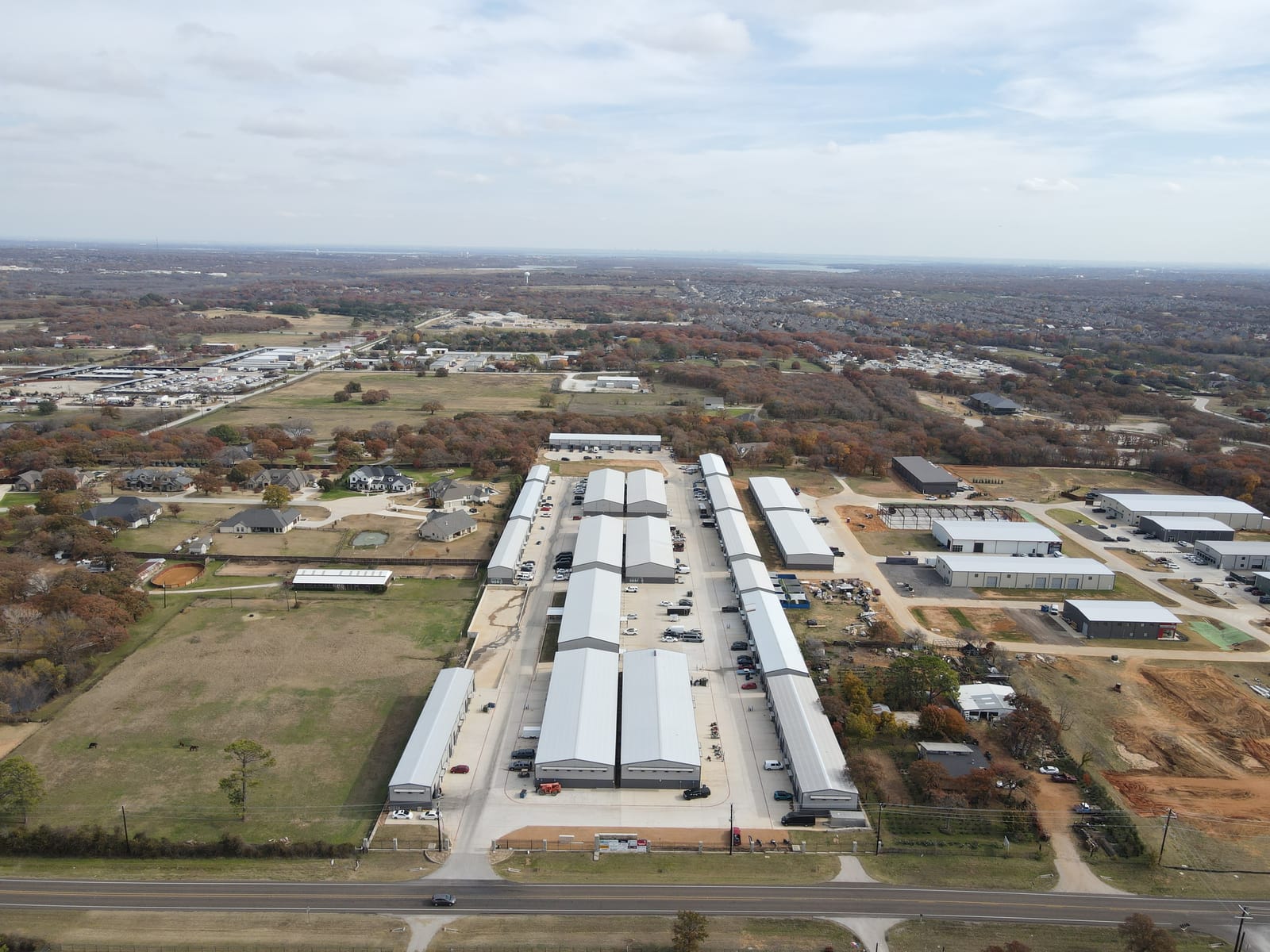 High aerial of a growth corridor, with a flex park along the highway and neighborhoods around it